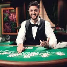 Dealer live casino tersenyum melayani pemain dalam sesi taruhan interaktif